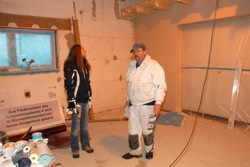 Vorsitzende bestaunt die erste verputzte Wand.