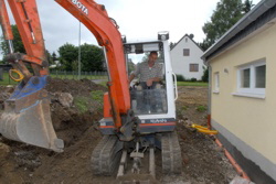 Herbert planiert den Weg vom / zum Parkplatz.